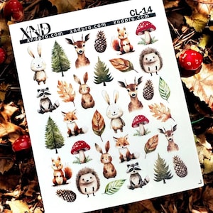 Puede incluir: Una hoja de pegatinas con ilustraciones de animales del bosque. Las pegatinas incluyen conejos, ciervos, zorros, ardillas, erizos, setas, piñas y hojas. El texto "xndpro.com" está impreso en la parte superior e inferior.