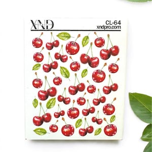 May include: A sheet of red cherry stickers with green leaves. The stickers are arranged in a repeating pattern. The sheet is labeled "XND Products" and "CL-64 xndpro.com".