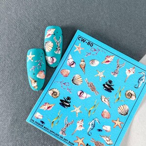 Könnte beinhalten: Eine blaue Folie mit Nagelaufklebern mit verschiedenen Designs zum Thema Meer, darunter Muscheln, Seesterne, Seepferdchen und Algen. Die Folie ist mit "CW-80" und "НА ЛЮБОЙ ФОН/APPLIED ON ANY BASE" beschriftet.