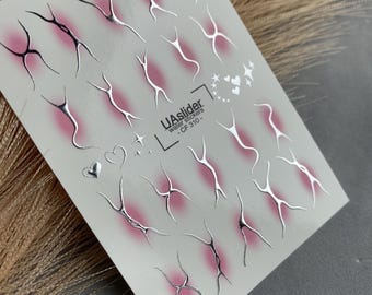 Puede incluir: Hoja de calcomanías de agua para nail art. Las calcomanías presentan un diseño plateado con un degradado rosa. La hoja incluye varias formas, incluyendo figuras abstractas, corazones y estrellas. El texto "UAslider Water Stickers - CF 310 -" está impreso.