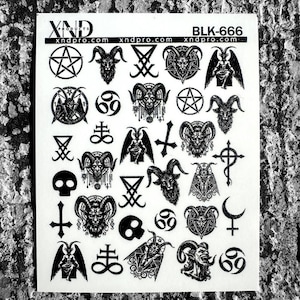 May include: A white sticker sheet with various black occult symbols, including pentagrams, goat heads, inverted crosses, and the number 69. The text "XND products" and "BLK-666" are also visible.