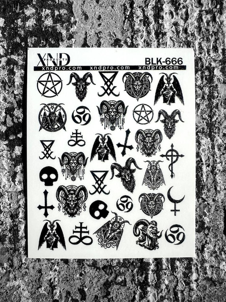 May include: A white sticker sheet with various black occult symbols, including pentagrams, goat heads, inverted crosses, and the number 69. The text "XND products" and "BLK-666" are also visible.