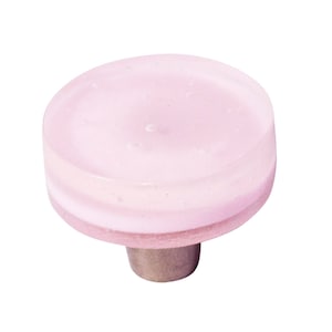 Könnte beinhalten: Ein pinkfarbener Glas-Schrankknopf mit silberner Basis.