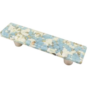 Puede incluir: Un tirador de armario rectangular de color azul claro con un patrón moteado blanco y marrón.