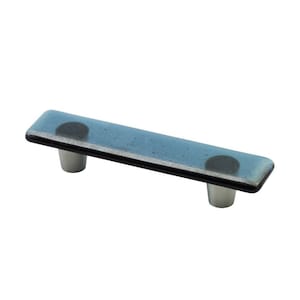 May include: A blue glass cabinet pull with a black trim and two silver knobs.