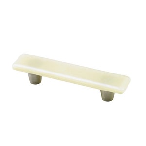 Puede incluir: Un tirador rectangular para armario con acabado blanco crema y dos postes de níquel cepillado. Este herraje está diseñado para cajones y armarios, ofreciendo una estética moderna.