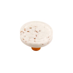 May include: White ceramic knob with a speckled finish and a gold base.