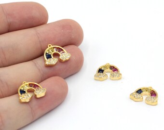 May include: Three gold-tone rainbow charms with clear and colourful crystals. Each charm features a rainbow arch with clouds on either side.