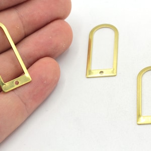 May include: Three gold-colored metal rectangular frames with rounded tops and a hole in the bottom.