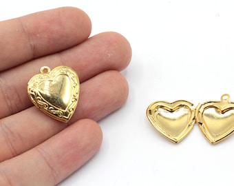 May include: Two gold heart-shaped locket pendants. One pendant is closed and the other is open, showing the inside of the locket.