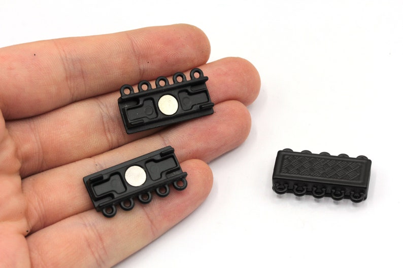 May include: Three black magnetic clasps for jewellery making. Each clasp has five loops and a magnetic closure.