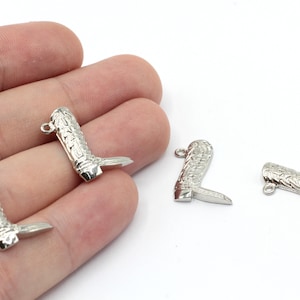 May include: Four silver cowboy boot charms with intricate details. The charms have a loop at the top for attaching to jewelry or other crafts.