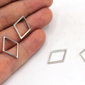 May include: Three silver diamond-shaped metal frames. The frames are hollow and have a smooth, polished finish.