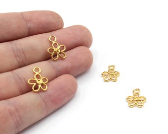 May include: Three gold-colored flower-shaped charms with a loop at the top. The charms are made of metal and have a delicate design.