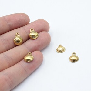 May include: Five gold-colored metal seashell charms with a loop at the top for attaching to jewelry or other crafts.