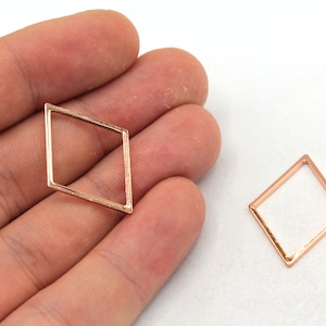 May include: Two rose gold diamond-shaped metal frames. The frames are open and have a smooth finish.