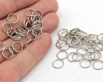 Könnte beinhalten: Ein Haufen silberner Sprungringe, eine Art Metallring, der in der Schmuckherstellung und im Handwerk verwendet wird.