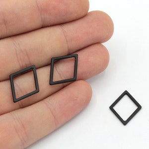 May include: Three black diamond-shaped earrings with a hollow center.