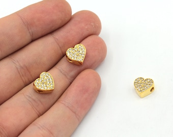 May include: Three gold heart-shaped charms with clear rhinestones. The charms have a hole for threading.
