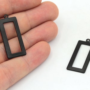 May include: Two black metal rectangular frame pendants with a loop at the top for hanging.