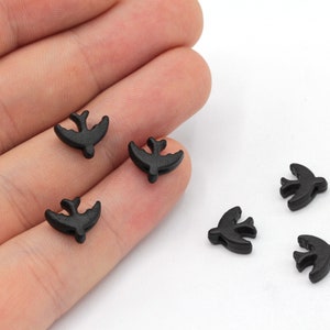 May include: Six black wooden bird-shaped beads. The beads are about 1 inch long and have a simple design.