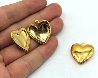 May include: Two gold heart-shaped locket pendants. One locket is open, revealing the inside. The lockets have a shiny finish.