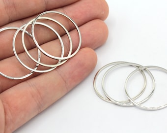 May include: Set of six silver metal rings, some are stacked on top of each other.