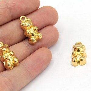 May include: Three gold-colored gummy bear charms with a loop for attaching to jewelry or other crafts.