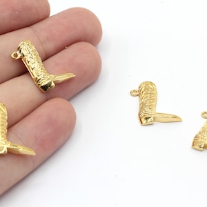 May include: Four gold-colored metal boot charms. The charms are detailed with a boot design and have a loop for attaching to a necklace, bracelet, or keychain.
