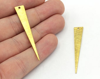 May include: Two gold-colored metal triangle shapes with a textured surface. Each triangle has a small hole at the top.