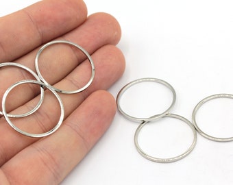 May include: Six silver jump rings, three of which are stacked on top of each other, and three of which are stacked on top of each other. The rings are all the same size and are made of a smooth, shiny metal.