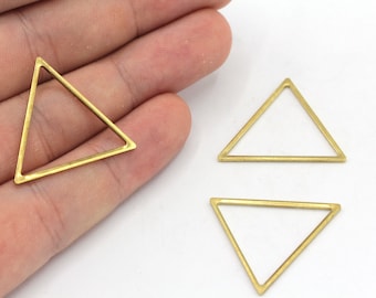 May include: Three gold-toned metal triangle shapes. The triangles are hollow and have a smooth, polished finish.