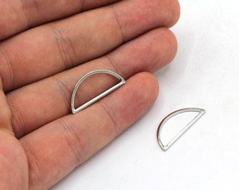 May include: Two silver half-circle metal rings, also known as D-rings, are shown on a hand. The rings are about 1 inch in diameter.