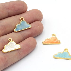 May include: Three gold-colored metal cloud charms with different colored enamel fills. The charms are blue, white, and orange.