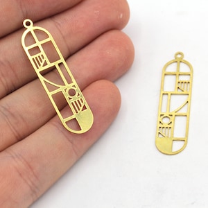 May include: Two gold-coloured, geometric pendant charms. Each charm is a long, narrow rectangle with a rounded bottom and a small loop at the top. The charms feature a cut-out design of geometric shapes.