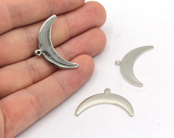 May include: Three silver crescent moon charms with a hole at the top for hanging.