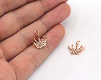 以下が含まれることがあります： クリアなラインストーンのアクセントが付いた、ゴールドトーンのクラウンチャーム2個。チャームの上部にループがあり、ジュエリーに取り付けることができます。