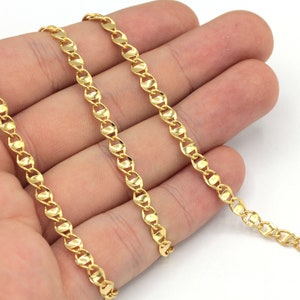 May include: Three strands of gold chain, each with a slightly different pattern, are laid out on a hand. The chains are all about 18 inches long.