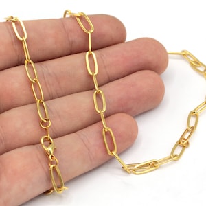 May include: A gold chain necklace with a lobster clasp closure. The chain is made of oval-shaped links.
