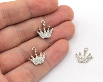 May include: Three silver crown charms with clear rhinestone accents. The charms have a loop at the top for attaching to jewelry.
