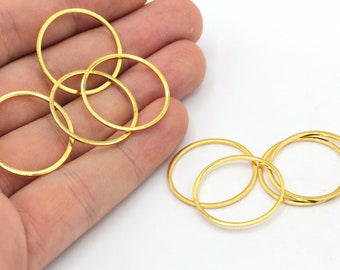 May include: A set of six gold-colored metal jump rings. The rings are round and have a smooth finish. They are perfect for jewelry making or other crafting projects.