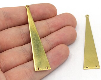 May include: Two brass-colored, elongated triangle charms with a hole at the top and two holes at the bottom. One charm is held in a hand, while the other lies on a white surface. These charms are likely for jewelry making.