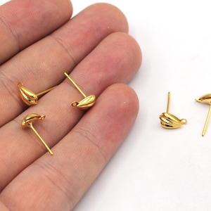 May include: Four gold-toned earring findings with a teardrop-shaped design. The findings have a small loop at the top and a post on the bottom.