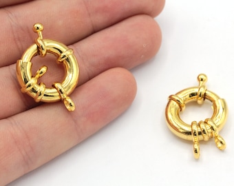 May include: Two gold-toned metal clasps with a round ring and two loops. The clasps are designed to be used as a closure for necklaces, bracelets, or other jewelry.