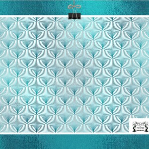May include: A white rectangular print featuring a teal fan-shaped pattern. The print is held by a black clip and a piece of twine against a teal textured background. The lower right corner has a logo with the text "Twisted Baubles".