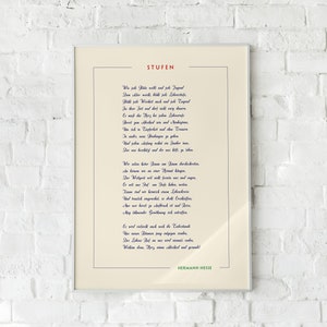 May include: A framed print of a poem titled "Stufen" by Hermann Hesse. The poem is written in German and is printed in blue ink on a cream background.