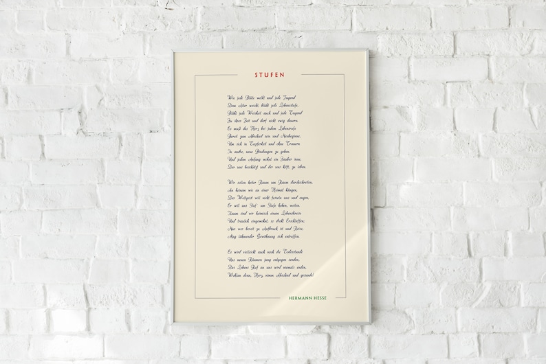May include: A framed print of a poem titled "Stufen" by Hermann Hesse. The poem is written in German and is printed in blue ink on a cream background.