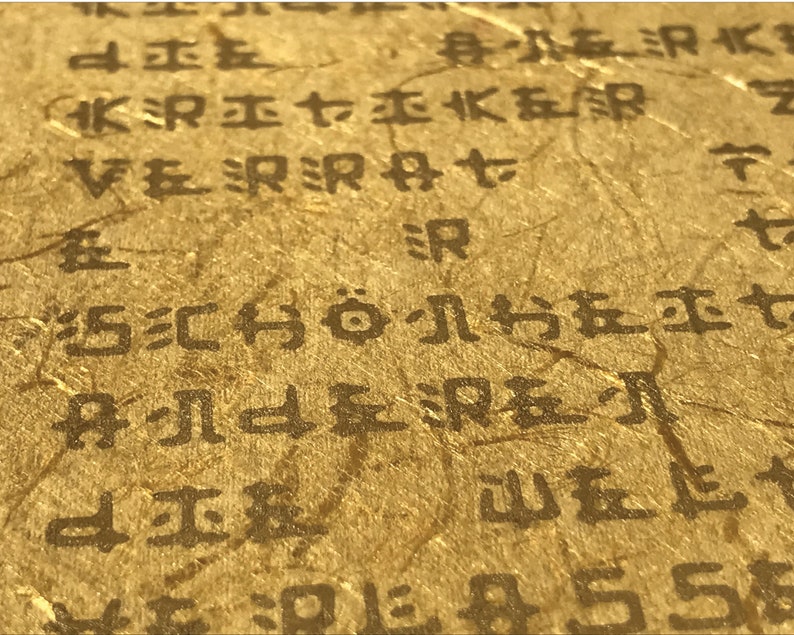 May include: Close-up of a textured, gold-coloured surface with black text. The text is in a foreign language and includes the word "SCH&Ouml;NE".