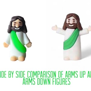 May include: Two small figurines of a religious figure, one with arms down and the other with arms up, are shown side by side. The figures have brown hair and beards, white robes, and green sashes. The text at the bottom reads "SIDE BY SIDE COMPARISON OF ARMS UP AND ARMS DOWN FIGURES."