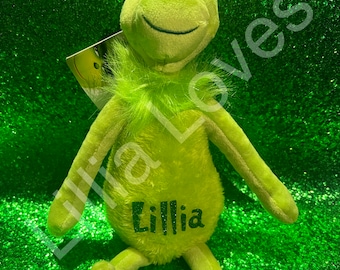 May include: Green plush Grinch toy with a furry green collar and a name tag that says "Lillia".